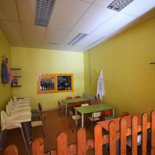 Comedor infantil decorado con cortinas de colores y valla de madera