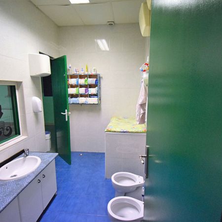 Baño infantil de puertas verdes y suelo azul